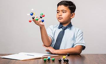 male student holding a model for a science assessment