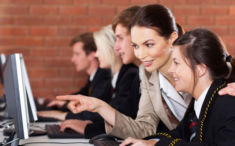 teacher with student using computer