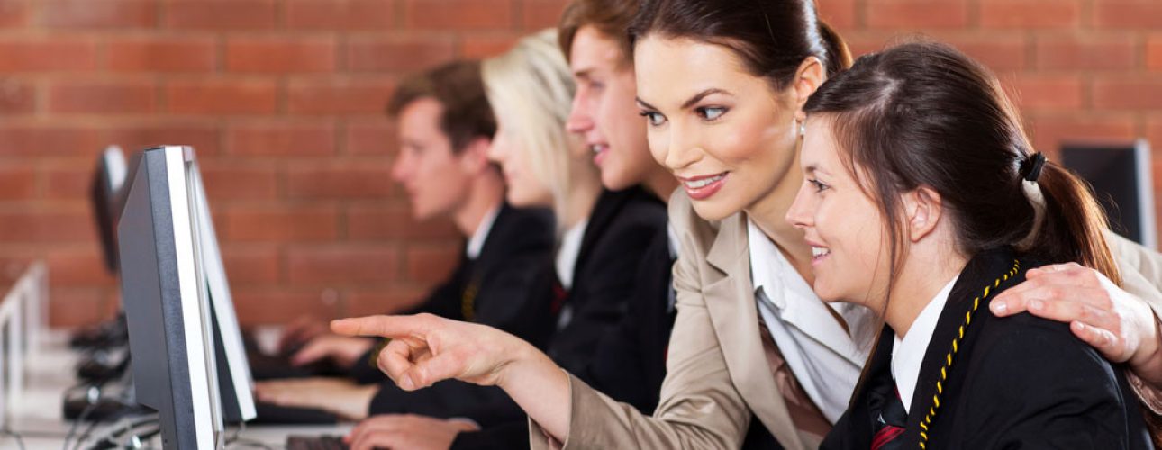 teacher with student using computer